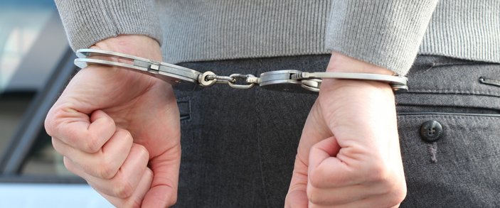 handen met handboeien persoon aangehouden